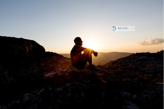 Person sitting outdoors at sunset, reflecting on recovery and child custody with help from a custody lawyer in Fairfax, Virginia.